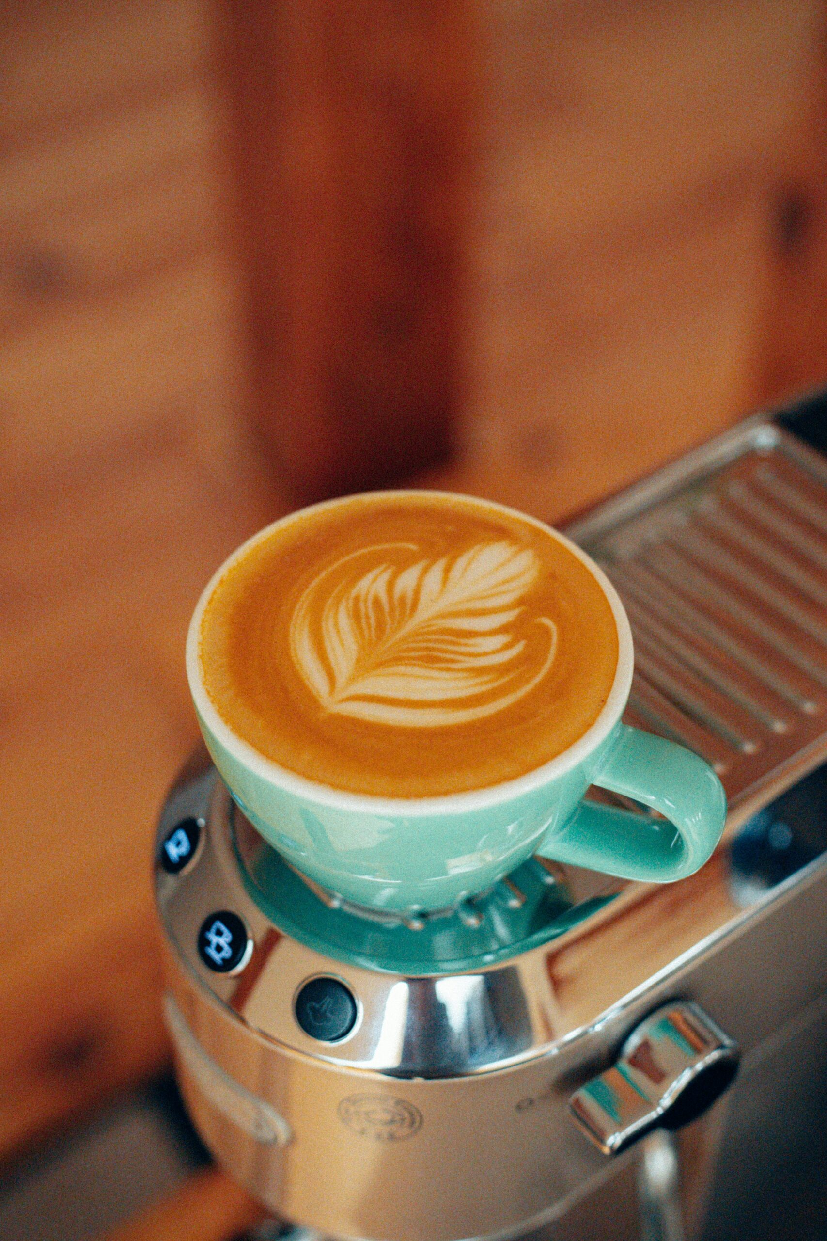A close-up shot of an espresso machine pouring fresh espresso into a glass, highlighting the rich crema and deep color of the coffee